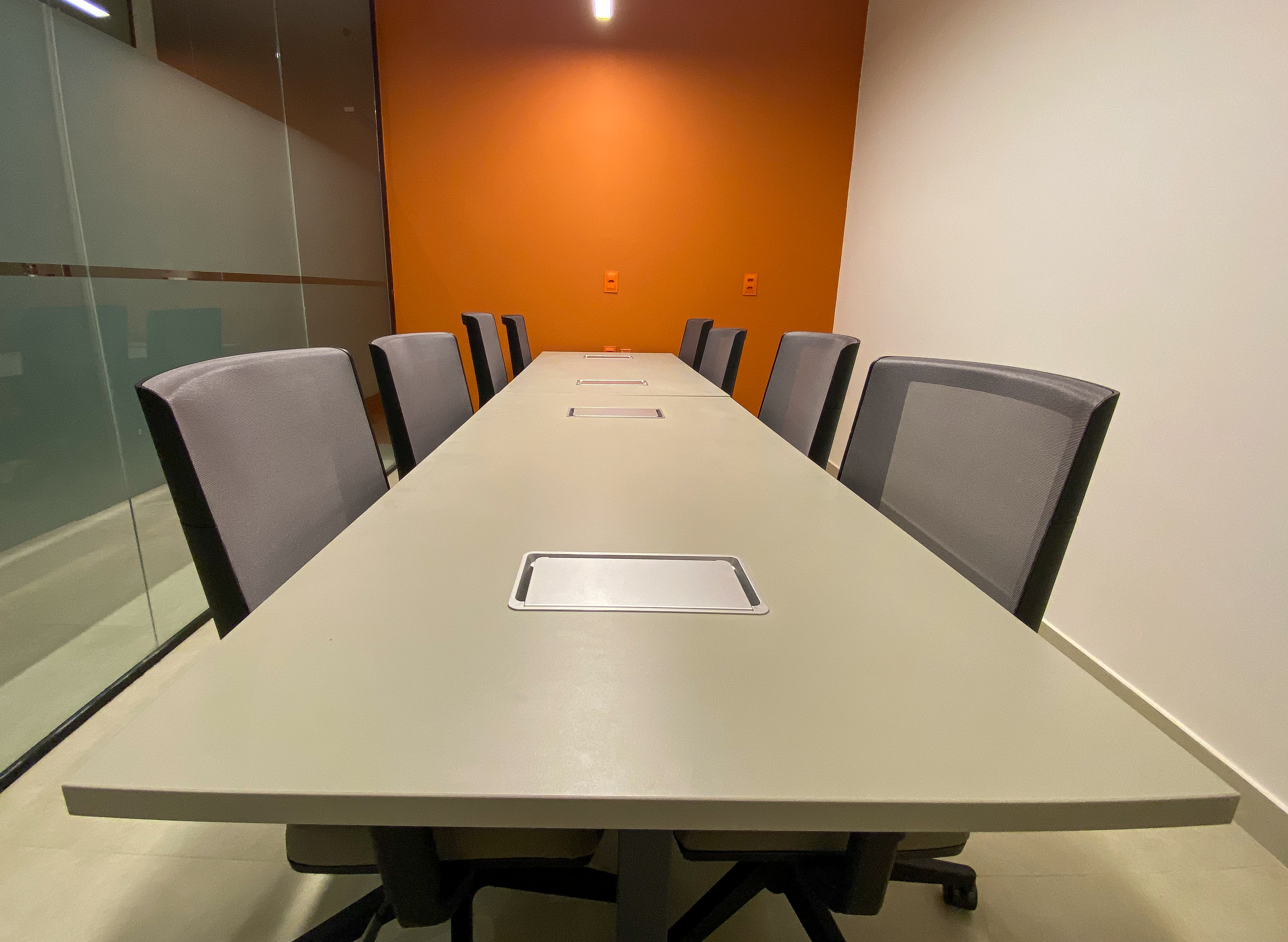 Sala com mesa grande de reunião